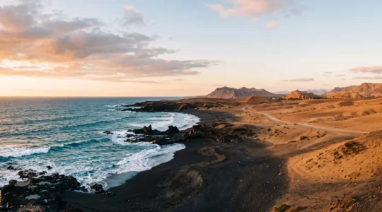 Paysage symbolique reliant les plages volcaniques des Canaries et les dunes desertiques du Maroc en une seule composition