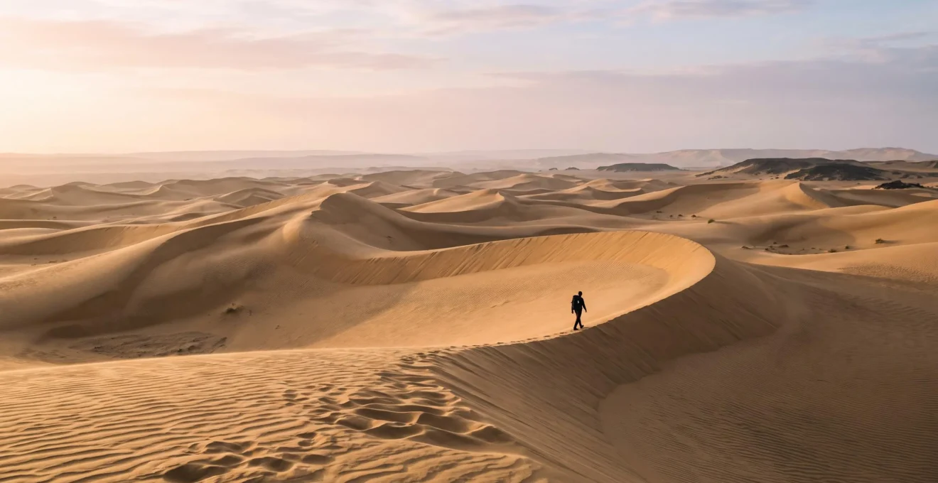 Randonneur solitaire traversant une immense dune dorée aux Canaries au lever du soleil