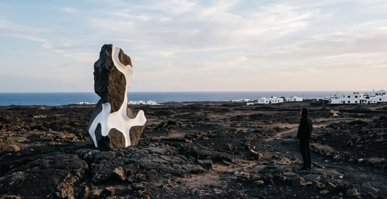 Sculpture d'art contemporain integree dans un paysage volcanique des Canaries au lever du soleil