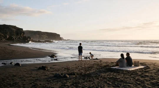 Famille profitant harmonieusement d'un coucher de soleil sur une plage volcanique des Canaries, entre détente et exploration