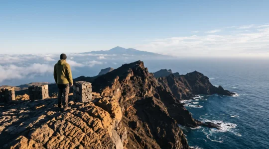 Silhouette contemplant un panorama vertigineux entre falaises volcaniques noires et océan Atlantique aux Canaries